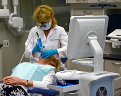 An operator positions the E4D wand over the tooth to be restored.