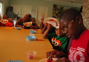Children visiting from Mommie Mika's Daycare show off the monster mouths they are making at the Tooth Fairy cottage.