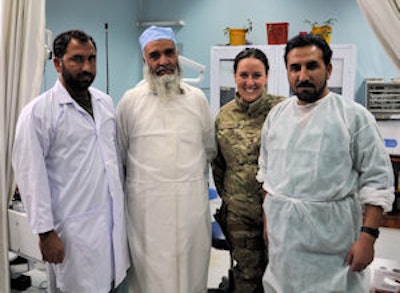 Air Force Maj. Courtney Schapira, DDS, poses with, from left, dental technician Nasir, dental clinic chief Dost Muhammad, and dentist Janat at Forward Operating Base Lightning in Afghanistan. Image courtesy of Staff Sgt. Sarah Martinez.