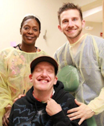 Patient Kristopher Warden (seated) with dental assistant Glendora Lester and Dr. Salvatore Colombo.