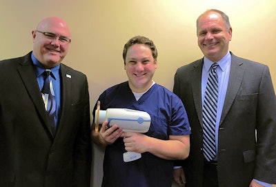 Richard Simpson, territory sales manager for the KaVo Kerr Group (left), and DrBicuspid.com National Sales Manager David Hurlbrink (right) award a Nomad Pro 2 to Thomas Runco, DDS.