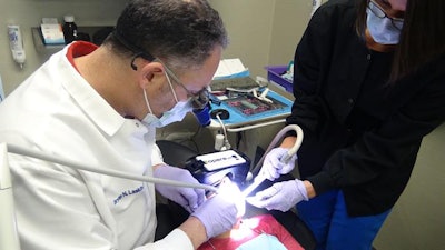 Dr. Bryan Laskin works on a patient immersed in a virtual reality experience. Image courtesy of OperaVR.