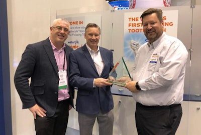 Accepting the award was Jay McCulloch (center), Water Pik's vice president of global marketing for oral care products, and Bart Prins (right), Water Pik's general manager and global vice president.
