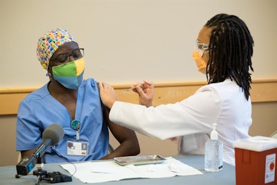 Cardiovascular intensive care nurse Ansu Drammeh received an injection of the Pfizer-BioNTech vaccine from dental resident Dr. Ryan Thrower. Image courtesy of OHSU/Fritz Liedtke.
