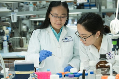 NYU College of Dentistry researchers and study authors Dr. Xin Li (left) and Dr. Yuqi Guo (right) work on a succinate preparation in the lab. Image courtesy of NYU Dentistry.