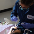 Dental therapist Sarah Chagnon treats a patient at the Swinomish Dental Clinic in La Conner, WA, as part of a school-based 'sealant week' program. More states are considering authorizing licensures of dental health aide therapists, also known as dental therapists. Experts say the midlevel practitioners can help fill gaps in access to dental health care. Image courtesy of Swinomish Dental Clinic.