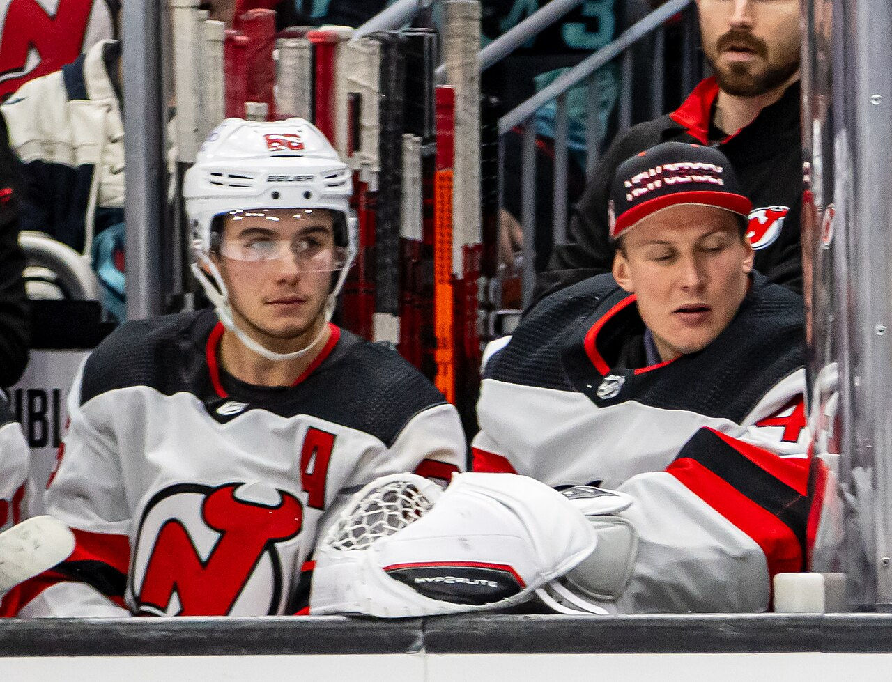 Hughes (pictured left) on the Devils bench during a December 2023 game.