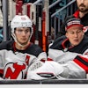 Hughes (pictured left) on the Devils bench during a December 2023 game.