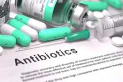 Green-and-white antibiotic capsules, tablets, syringes, and medication bottles arranged around an Antibiotics document.