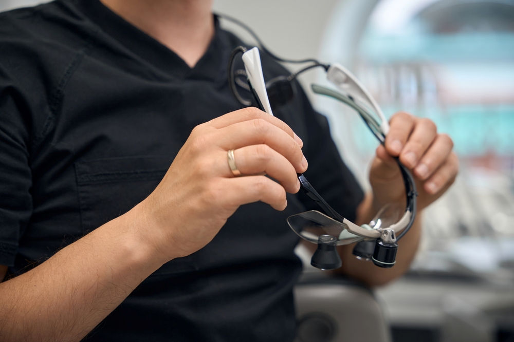 Close-up of a male dentist preparing to put on loupes.