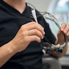 Close-up of a male dentist preparing to put on loupes.