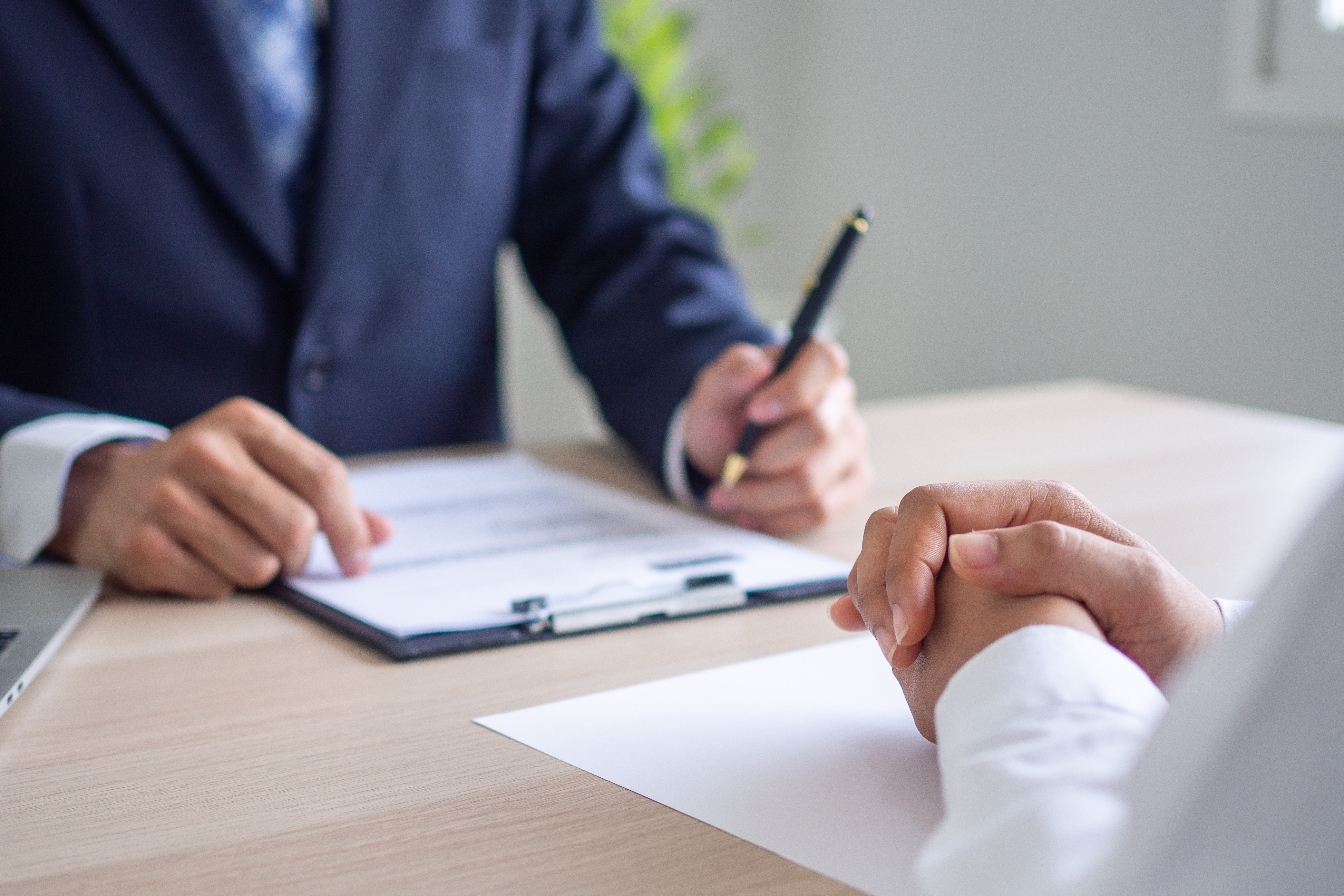 Two professionals review documents during a business meeting, representing formal discipline.