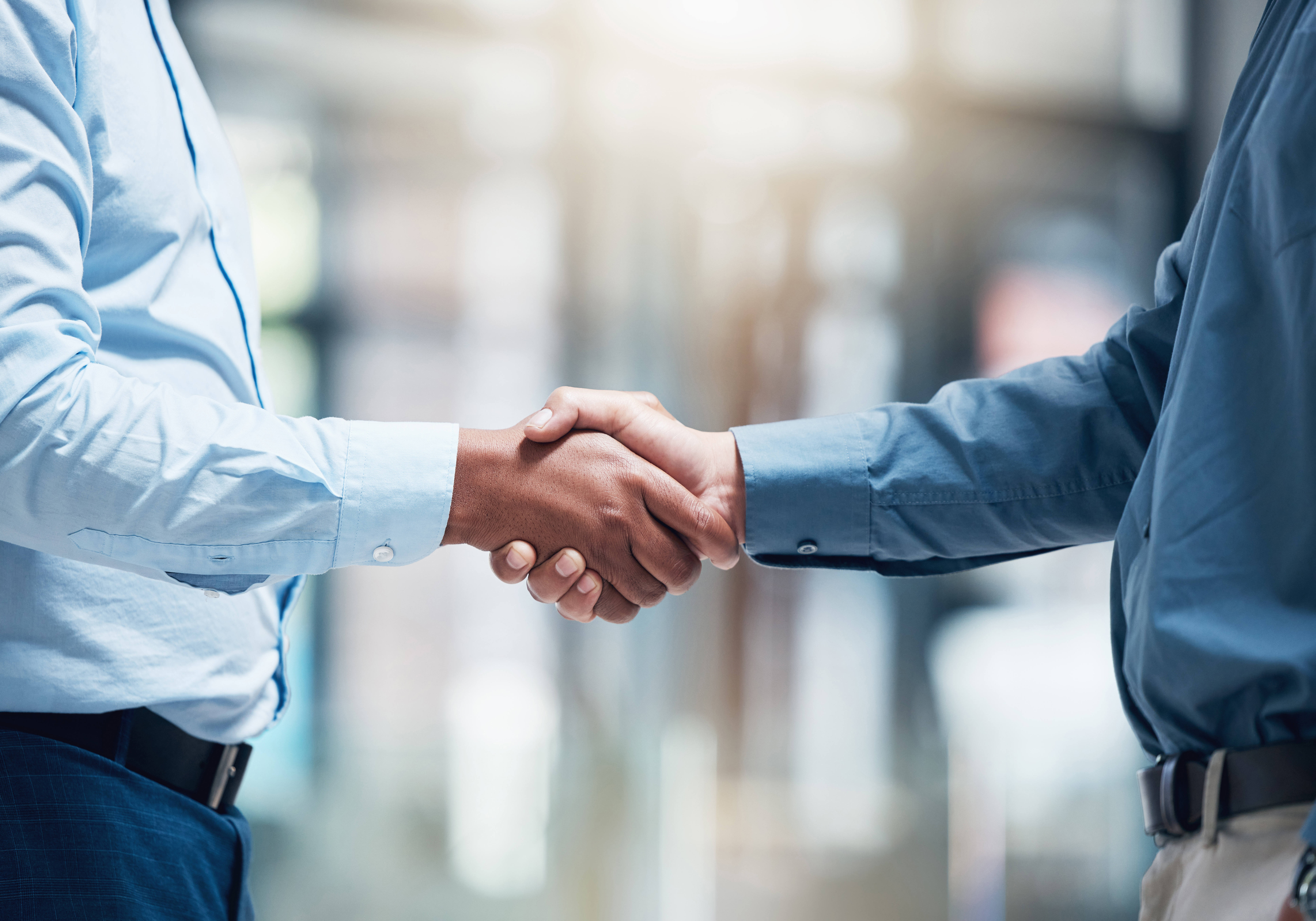Two male business professionals shake hands.