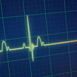 Glowing yellow-green heartbeat waveform with red endpoint on a dark blue grid background, signaling death.