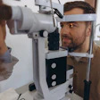 A male patient has his eyes examined by an opthomologist.