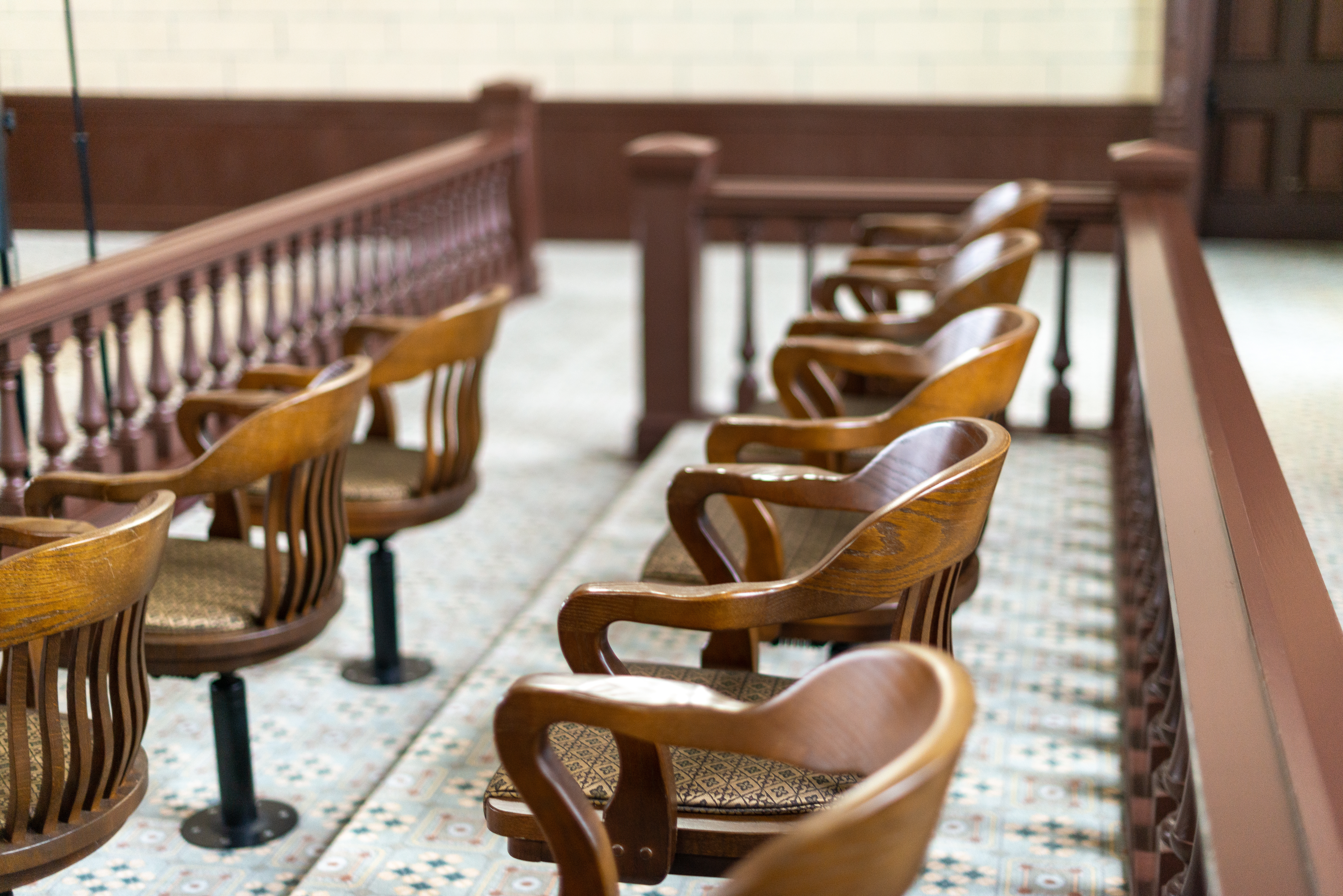 Empty wood jury chairs are shown.