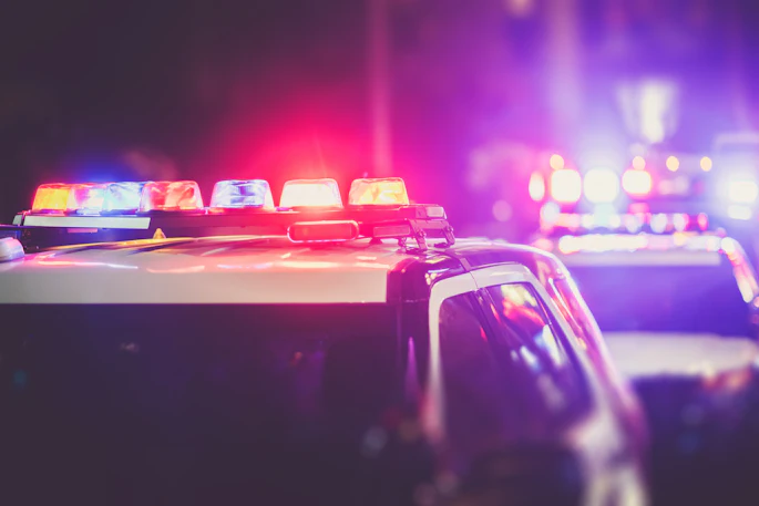 Police emergency vehicle lights flashing red and blue at night.