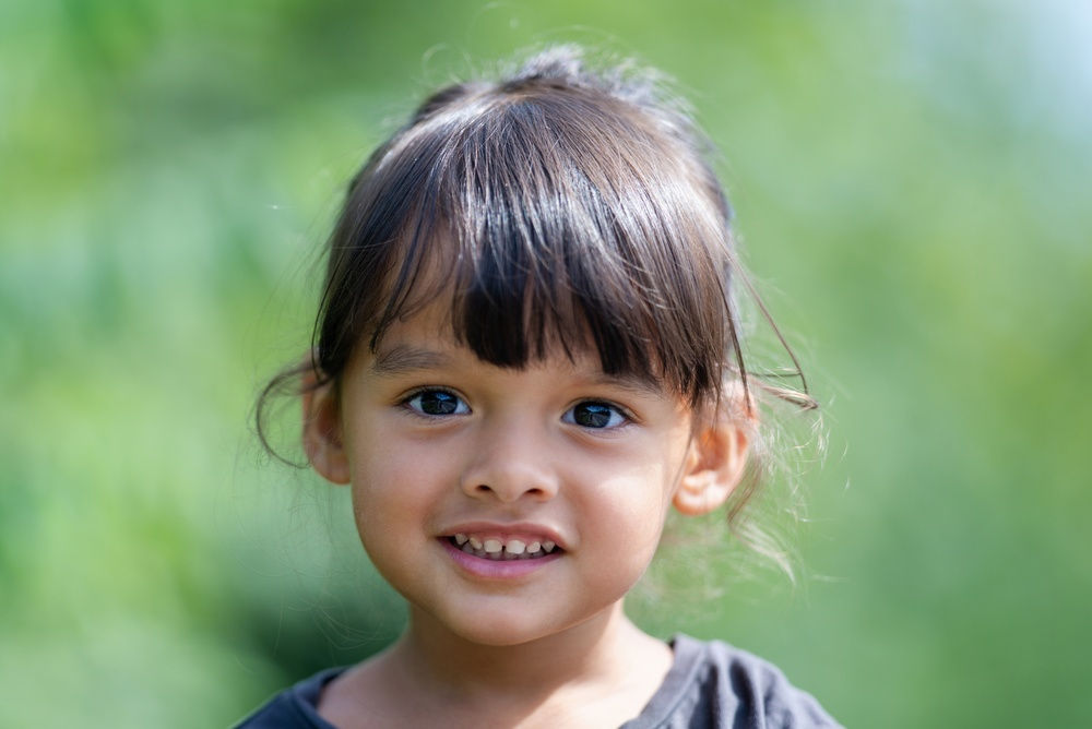 A young girl smiles as the viewer.