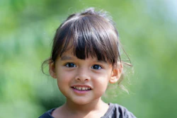 A young girl smiles as the viewer.