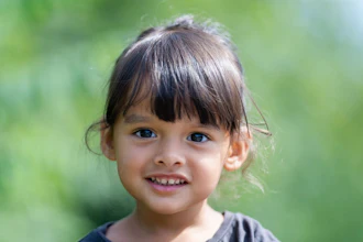 A young girl smiles as the viewer.